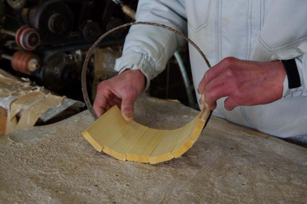  ▲仮のタガに沿って接着剤をつけた木材をならべていきます。