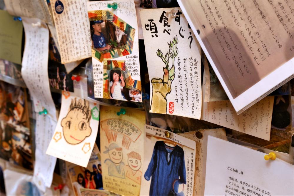 ▲囲炉裏のある部屋の壁は、お客さんのお礼の手紙や写真で埋め尽くされています。