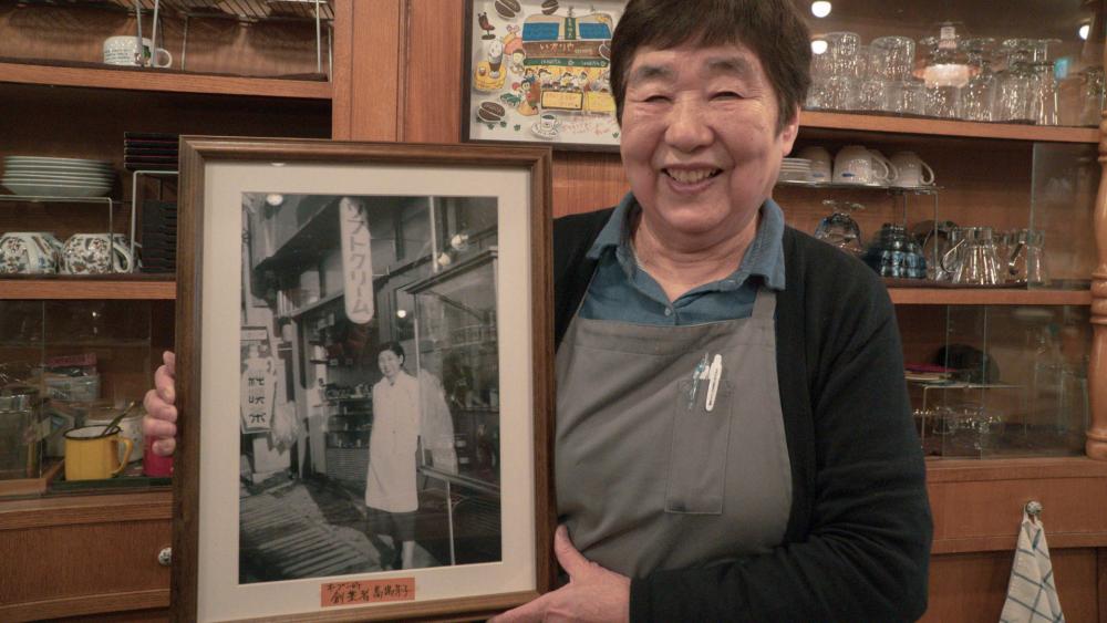 創業者 馬場芳子さんの写真を持つ二代目の智恵子さん