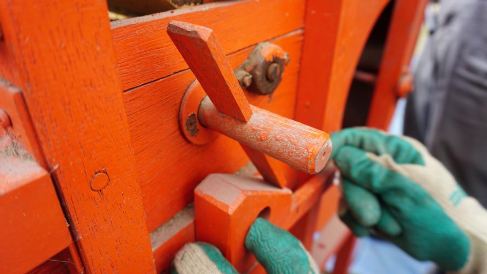  木のハンドルを回して、落ちてくる種の量を調整します